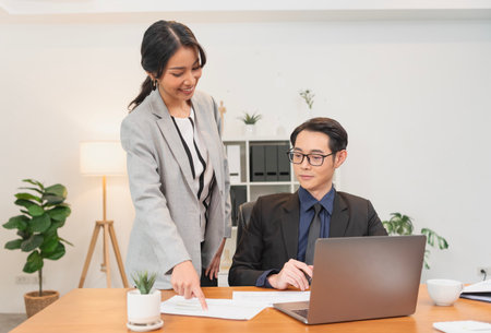 Smiling asian businesswoman showing document report to her manager during a meeting in the office. secretary and boss in the office discuss new strategies and business development plans.の写真素材