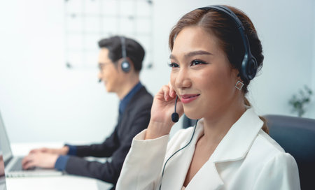 Asian call center agent team, customer service support wearing headset or headphone talking with...