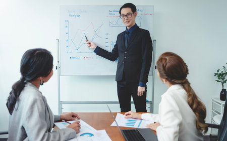 Asian businessman presenting of his work to corporate colleagues in meeting in office. businesspeople discussion during meeting about project of company.の写真素材