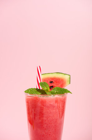 fresh watermelon juice or smoothie in glasses with watermelon pieces on studio background. Refreshing summer drinkの写真素材