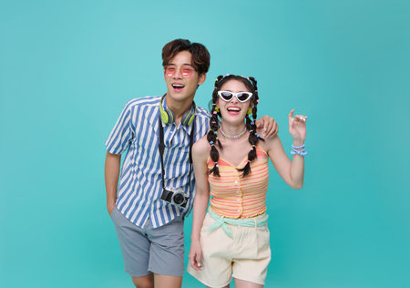 Happy young Asian couple dressed in summer clothes travel trip summer beach holiday isolated on blue...
