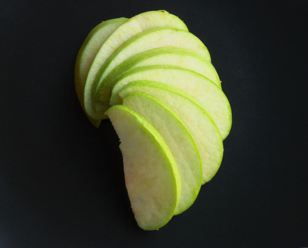 Green apple cut isolated on a black backgroundの写真素材