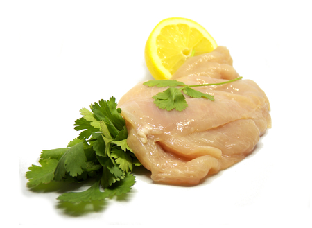 Fresh chicken breast isolated on a white background. Chicken breast with lemon and parsleyの写真素材