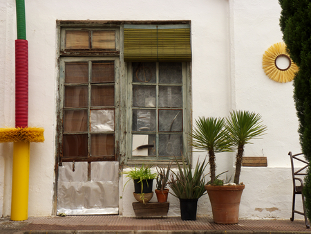 Vintage style door with white wall and flower potsの写真素材