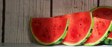 cut watermelon with a white wood background with light from the windowの写真素材