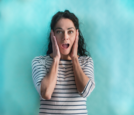 Beautiful hispanic woman wearing stripes sweater celebrating crazy and amazed for success with arms...