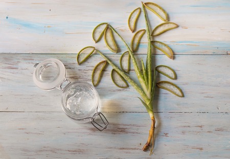 Natural aloe vera gel in glass jar with aloe vera plant, top viewの写真素材