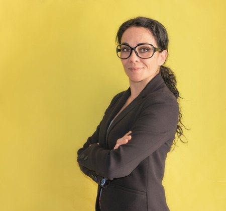 Brunette business woman with glasses, with arms crossed smiling at the camera. Profile personの写真素材