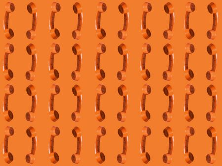 Seamless pattern of an orange retro style telephone, isolated on an orange background