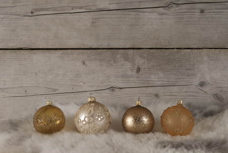 beautiful bronze and golden glass christmas baubles, on sheepskin and weathered wooden backgroundの写真素材