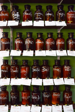 Brown glass bottles with natural spices in the shelf of a zero waste bulk groceries shop. A conscious choice for conscious people who save money eating healthy food.の写真素材