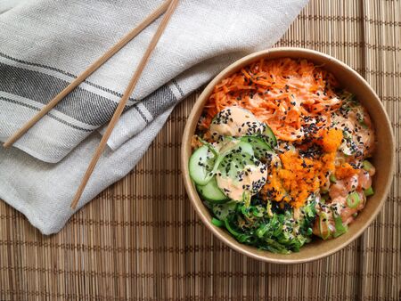 Top view of a salmon poke with chopsticks and a clothの写真素材