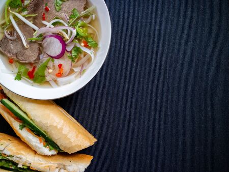 Soup from Vietnam and banh mi heo nuong on a gray background with copy spaceの写真素材