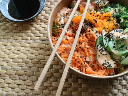 Wooden chopsticks on a bowl with traditional pokeの写真素材