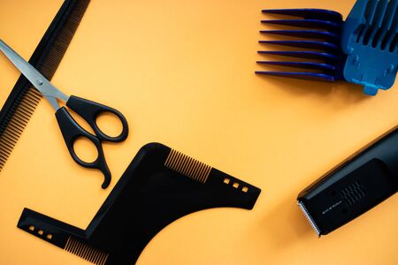 Barber set with scissors, comb, electric razor and heards on yellow background. Flat layの写真素材