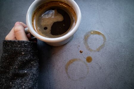 Woman hand holding a mug of spresso coffeee on concrete background. Blogging concept. Top viewの写真素材