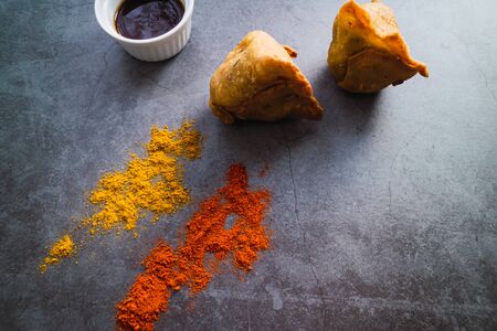 Free meat samosas with potatoes, peas and onion on concrete background. Indian food Top view