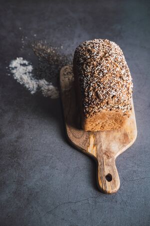 Brown bread with chia and sunflower seeds on wooden table