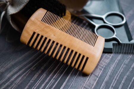Wooden comb and other tools for beard trimming in background. Close up view.の写真素材