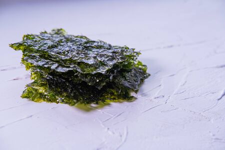 Seaweed chips on white textured background. Korean snack. Close up view. Copy space.の写真素材