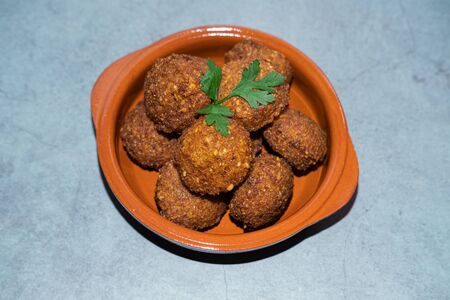 Chickpeas falafel isolated on a clay bowl decorated with parsley. Vegan food.