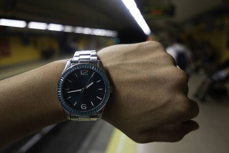 Hand with clock waiting for the subway to arrive at the stationの写真素材