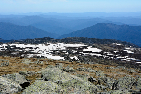 View from the highest peak of Australian mountains - Mount Kosciuszko. Range of Snowy Mountains covered with snow.の写真素材