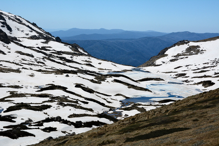 Trail to the highest peak of Australian mountains - Mount Kosciuszko. Range of Snowy Mountains covered with snow.の写真素材