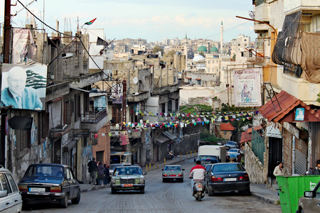 Lebanon, Tripoli; February 13th 2011  - Lebanese city life with posters of politicians -Najib Mikati. People walking, car on the street.のeditorial素材