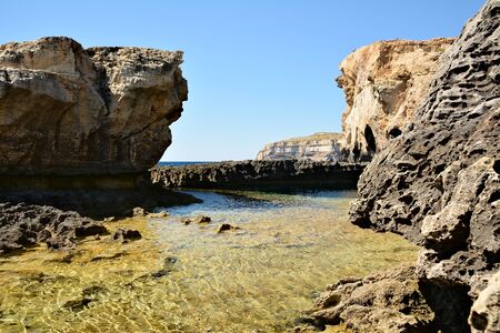 Dwejra Bay, with its dramatic coastal formations and sea spilling over the rocks, is a magical attraction. Here you can swim in the spectacular deep sea of the bayの写真素材
