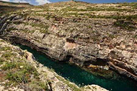 Wied il-Ghasri gorge with clean green water surrounded by high clifs; 250m longの写真素材