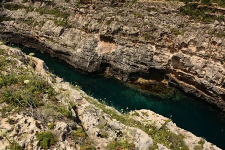 Wied il-Ghasri gorge with clean green water surrounded by high clifs; 250m longの写真素材