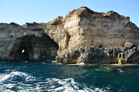 High cilfs with caves on Cominotto Island, near famous Comino Islandの写真素材