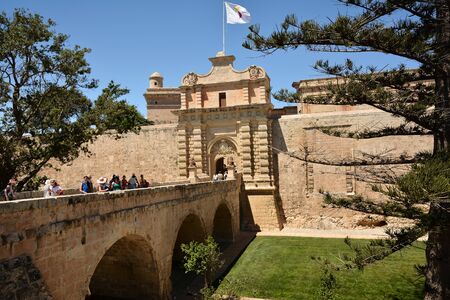 Rabat; June 4th 2019 Malta - Old bridge with main gate to the Old Town of Mdina; tourists walking on the bridgeのeditorial素材