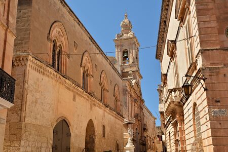 One of the old town streets of Mdina/Rabat with historical buildings and decorative carvingsの写真素材