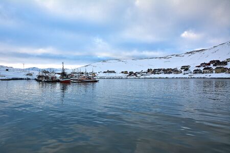 Skarsvag is a village in Nordkapp Municipality. The village lies along the northern coast of the island of Mageroya, and it claims the distinction of being the world's northernmost fishing village. Fishing boats and houses on a hill full of snow during winter time.の写真素材