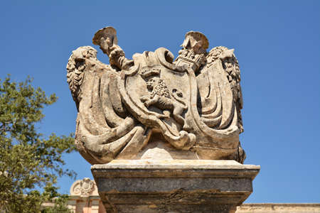 Malta, Rabat, June 4th 2019 - Architectonical carvings in front of the old bridge with main gate to the Old Town of Mdina; tourists walking on the bridgeのeditorial素材