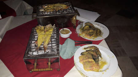 Dinner consisting of seafood accompanied by grilled vegetables, potatoes or rice. Grilled crabs, shrimps, squid.の写真素材