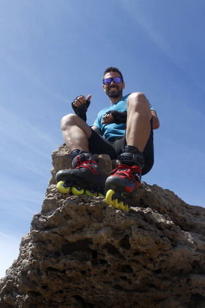 Guy smiling sitting on a rock, Cascais, Lisbon, Portugalの写真素材