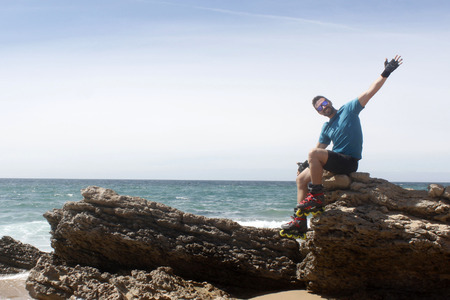 man on a rock with his arms open