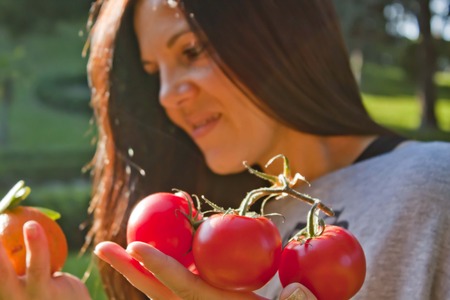 Woman with tomatoes and a mandarinの写真素材