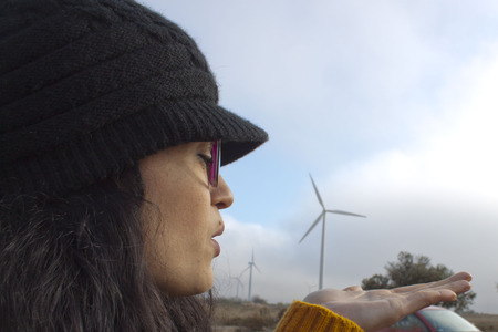 girl blowing to a mill over her handの写真素材