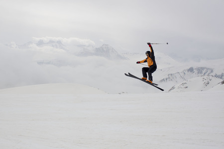 skier jumping with a range mountain backgroundの写真素材