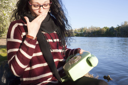 woman surprised because of an antique phoneの写真素材