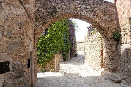 Street and an arch made of stone in Peratallada, Spainの写真素材