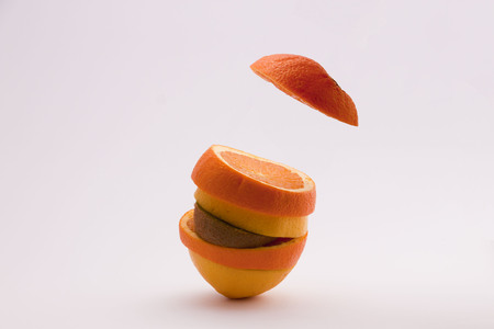 opened orange cut with a lemon and a kiwiの写真素材