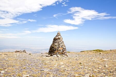 Pillar of stones over the Moncayo mountain with a blue sky in Spainの写真素材