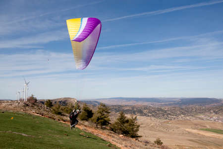 Paraglider taking off the earth in the mountains a sunny dayの写真素材