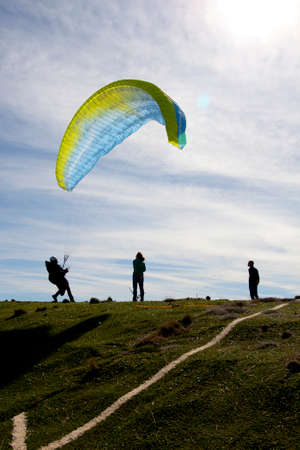 man trying to control the paraglide with friendsの写真素材