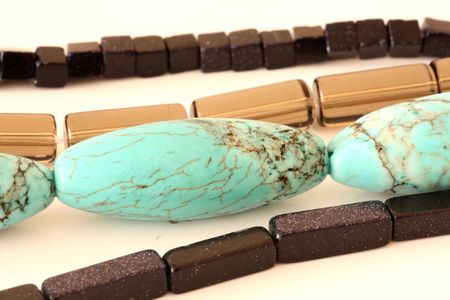 turquise black and smoky beads on white backgroundの写真素材